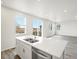 Bright kitchen features stainless steel appliances, white cabinetry and countertops, and wood flooring at 1937 S Coolidge Way, Aurora, CO 80018