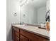 Bathroom vanity with warm wood cabinets, a large mirror, and ample counter space at 5830 Ceylon St # B, Denver, CO 80249