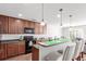 Well-lit kitchen with dark wood cabinets, pendant lights, stainless steel appliances, and breakfast bar seating for three at 5830 Ceylon St # B, Denver, CO 80249