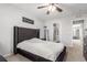 Bedroom featuring a plush bed, ceiling fan, and a view of the ensuite bathroom at 5830 Ceylon St # B, Denver, CO 80249