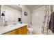 Well-lit bathroom with a single sink, framed mirror, and a shower/tub combination with tile surround at 7700 W Grant Ranch Blvd # 4A, Littleton, CO 80123