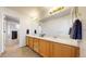 Bright bathroom has a double vanity, wood cabinets, and shower with sliding glass doors at 7700 W Grant Ranch Blvd # 4A, Littleton, CO 80123