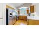 Bright kitchen features wooden cabinetry, stainless steel appliances, hardwood flooring and large arched window at 7700 W Grant Ranch Blvd # 4A, Littleton, CO 80123