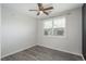 Cozy bedroom with new flooring featuring a ceiling fan, and a window offering neighborhood views at 7090 Simms St # 202, Arvada, CO 80004
