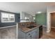 Open kitchen featuring a breakfast bar with sink and views into the dining and living areas at 7090 Simms St # 202, Arvada, CO 80004