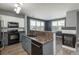 Modern kitchen with stainless steel appliances, granite countertops, and stylish two-tone cabinets at 7090 Simms St # 202, Arvada, CO 80004