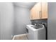 Functional laundry room featuring a modern, front-load washer and dryer with overhead cabinets for added storage at 7090 Simms St # 202, Arvada, CO 80004