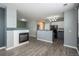 Open concept living area with fireplace, views of kitchen, and wood-style flooring at 7090 Simms St # 202, Arvada, CO 80004