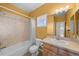 Bright yellow bathroom featuring a shower-tub, tile surround, and a wood vanity at 12747 Bestview Dr, Larkspur, CO 80118