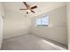 Bright bedroom featuring neutral carpet, a ceiling fan, and a large window with bright natural light at 12747 Bestview Dr, Larkspur, CO 80118