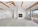 Bright living room featuring a fireplace, vaulted ceilings with beams, and access to a deck with beautiful views at 12747 Bestview Dr, Larkspur, CO 80118