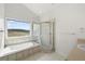 Main bathroom featuring a soaking tub under a window with scenic views and a separate shower at 12747 Bestview Dr, Larkspur, CO 80118