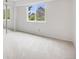 Bright bedroom with neutral carpet, white walls, and a window with a view of mature trees at 7395 E Quincy Ave # 206, Denver, CO 80237