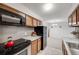 Well-lit kitchen with stainless steel appliances, wooden cabinets, and granite countertops at 7395 E Quincy Ave # 206, Denver, CO 80237