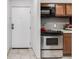 Modern kitchen with stainless steel appliances, light wood cabinets, and sleek countertops near entrance at 7395 E Quincy Ave # 206, Denver, CO 80237