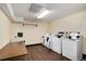 Bright laundry room with multiple washers, dryers, folding table, and sink at 7395 E Quincy Ave # 206, Denver, CO 80237