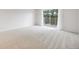 Bright and spacious living room featuring white walls, neutral carpet, and a sliding glass door to the deck at 7395 E Quincy Ave # 206, Denver, CO 80237