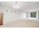 Spacious living room featuring white walls, neutral carpet, and a sliding glass door to the deck at 7395 E Quincy Ave # 206, Denver, CO 80237