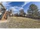 Backyard view of a large grassy area with a deck and fence, offering space for outdoor activities at 10408 Strasburg Way, Parker, CO 80134