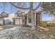 Two-story home featuring tan siding with a brick accent and a tree in the front yard at 10408 Strasburg Way, Parker, CO 80134