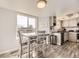 Open concept kitchen featuring white cabinets, stainless steel appliances, and a dining area at 10408 Strasburg Way, Parker, CO 80134