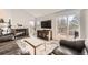 Bright living room featuring a brick fireplace, TV, sliding door access to a deck, and weathered floors at 10408 Strasburg Way, Parker, CO 80134