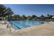 Community pool with crystal-clear water, featuring lounge chairs, umbrellas, and lifeguard stands at 10408 Strasburg Way, Parker, CO 80134