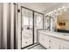 Modern shower room with marble walls, a glass door, and a built-in bench and shelf at 10408 Strasburg Way, Parker, CO 80134