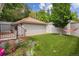 Beautiful backyard featuring artificial grass, lovely flower garden, cozy hammock, and convenient garage access at 600 Vine St, Denver, CO 80206