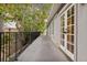 Spacious covered balcony with wooden floors, framed by trees and access to the house through glass paneled doors at 600 Vine St, Denver, CO 80206