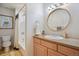 Bathroom featuring a vanity with a round mirror, a bathtub with shower, and vintage-inspired decor at 600 Vine St, Denver, CO 80206