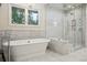 Luxurious bathroom with marble tiling, a standalone tub, and a glass-enclosed shower with a window view at 600 Vine St, Denver, CO 80206