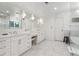 Elegant bathroom with double vanity, marble countertops and floors, decorative mirrors, and a glass enclosed shower and bath at 600 Vine St, Denver, CO 80206