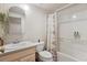 Bright bathroom featuring a shower-tub combo, neutral vanity, and stylish mirror at 600 Vine St, Denver, CO 80206