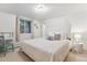 Bright bedroom with a white bed, a desk, a crystal light, and a view of the outdoors through a window at 600 Vine St, Denver, CO 80206