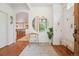 Bright and open foyer with hardwood floors, a round mirror, and an arched entrance to the kitchen at 600 Vine St, Denver, CO 80206