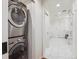 Hallway leading to a bathroom with a modern washer and dryer combo and stylish marble tiling at 600 Vine St, Denver, CO 80206