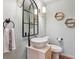 Stylish powder room features a vessel sink, arched mirror, and hexagonal shelves for a modern touch at 600 Vine St, Denver, CO 80206