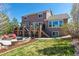 Spacious backyard with a stone patio, tiered deck, and lush landscaping, perfect for outdoor entertaining at 1863 Rose Petal Ct, Castle Rock, CO 80109