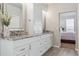 Bright bathroom featuring double sinks with granite counters and view through the ensuite bathroom door to main bedroom at 1863 Rose Petal Ct, Castle Rock, CO 80109