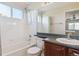 Bathroom features single sink, bath and shower, and view into bedroom, all brightly lit by window at 1863 Rose Petal Ct, Castle Rock, CO 80109