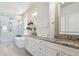 Bright bathroom features double sinks with granite counters, soaking tub under a chandelier, and glass enclosed shower at 1863 Rose Petal Ct, Castle Rock, CO 80109