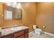 Powder room featuring a granite countertop, wood vanity, and tile floors at 305 Inverness Way # 102, Englewood, CO 80112