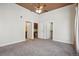 Spacious main bedroom with neutral carpet, high ceilings and ceiling fan leading to a private bathroom at 305 Inverness Way # 102, Englewood, CO 80112