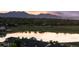 Serene lake reflects the sky in this aerial view of townhomes, and mountain views at 2154 Concord Ln, Superior, CO 80027