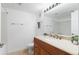 Bright bathroom featuring wood vanity, tile floors, and shower with tub, and a large mirror at 2154 Concord Ln, Superior, CO 80027
