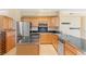 Open kitchen with stainless steel appliances, black countertops, and wood cabinetry at 2154 Concord Ln, Superior, CO 80027