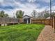Green backyard featuring a shed, garden boxes, wooden fence, and stone pathway at 2849 S Bannock St, Englewood, CO 80110