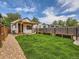 Lovely backyard with lush green lawn, gravel pathway, pergola, and garden boxes at 2849 S Bannock St, Englewood, CO 80110