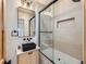 Stylish bathroom features a black sink, unique light fixtures, and tub with glass door at 2849 S Bannock St, Englewood, CO 80110